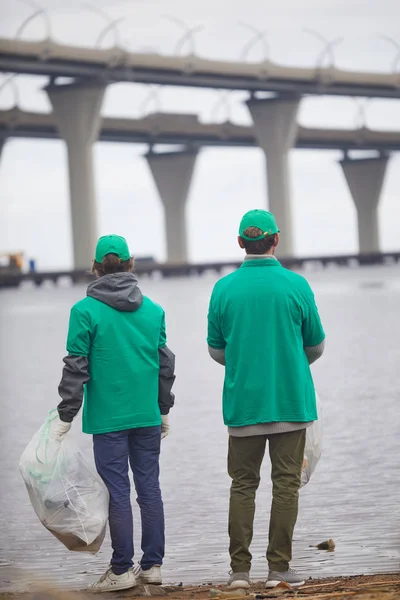 Widok Tyłu Dwóch Mężczyzn Zielony Jednolite Stojący Nad Rzeką Podczas — Zdjęcie stockowe