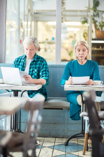 Dos Profesionales Ocupados Sentados Junto Mesas Individuales Leyendo Información Documentos — Foto de Stock