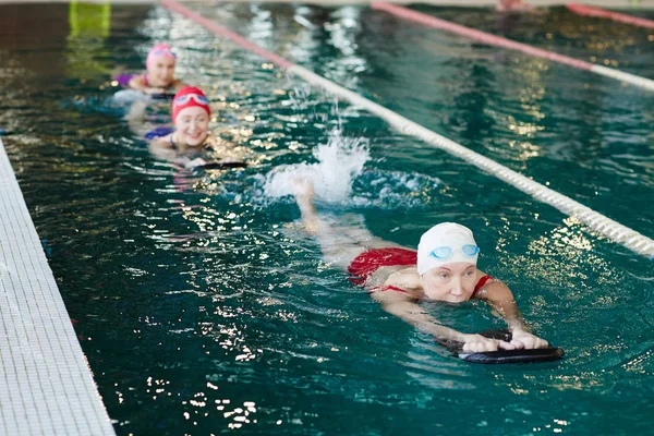 Fila Mujeres Maduras Nadando Piscina Una Tras Otra Mientras Entrenan —  Fotos de Stock