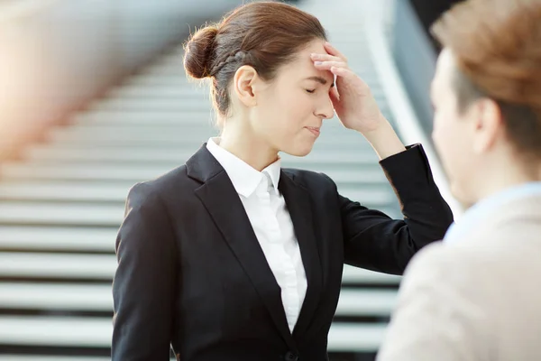 Besorgte Geschäftsfrau Berührt Ihren Kopf Während Kollegin Sie Einige Arbeitspläne — Stockfoto