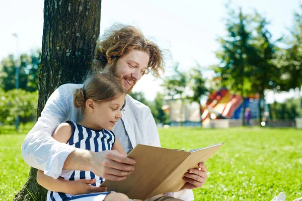 Glücklicher Junger Mann Mit Aufgeschlagenem Märchenbuch Beim Lesen Mit Seiner — Stockfoto