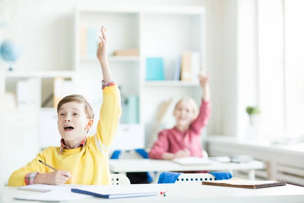 彼の場所からの答えを見ている先生の手を上げながら幸せな少年 — ストック写真