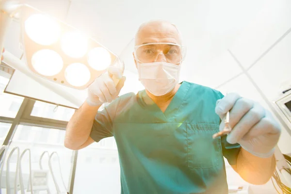 Reifer Zahnarzt Mit Kontrollinstrument Der Vor Der Zahnuntersuchung Lampe Auf — Stockfoto