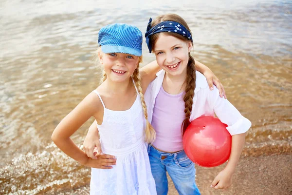 Freundliche Mädchen Die Sich Umarmen Während Sie Die Kamera Schauen — Stockfoto