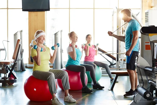 Group Senior Women Lifting Dumbbells While Sitting Fitballs Front Young — Stock Photo, Image