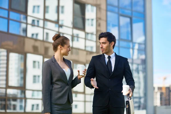 Dos Jóvenes Gerentes Elegantes Con Bebidas Hablando Mientras Caminan Casa — Foto de Stock