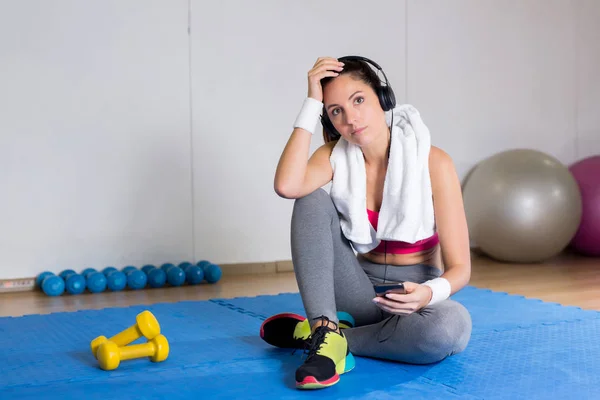 Girl Tired Workout Sitting Mat Listening Music Headphones Gym — Stock Photo, Image