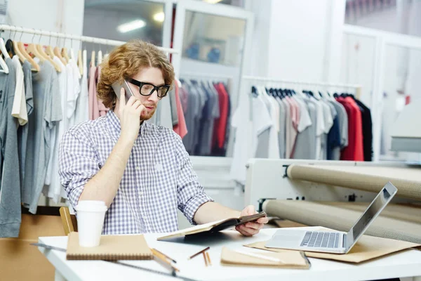 Jonge Man Praten Aan Telefoon Zijn Kladblok Kijken — Stockfoto