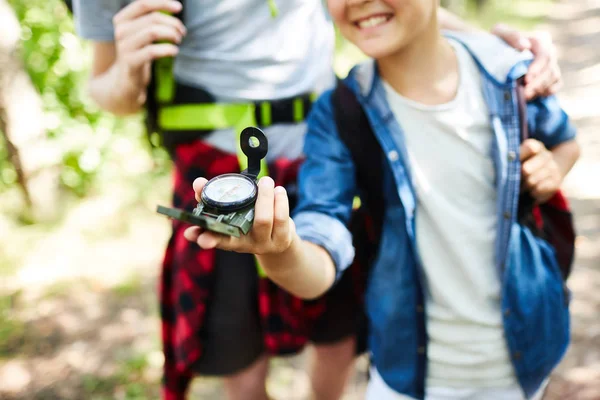 若い男の子スカウト彼の仲間の森のキャンプを探しながらコンパスの矢印後ウォーキング — ストック写真