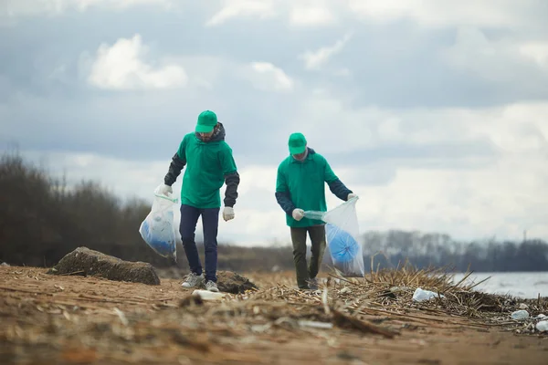 Twee Mannen Met Grote Zakken Wandelen Langs Rivieroever Oppakken Van — Stockfoto