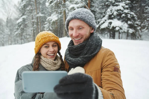 Affectionate Guy Girl Winterwear Holding Smartphone Front Themselves While Making — Stock Photo, Image