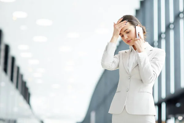 Joven Empleada Tocándose Cabeza Mientras Habla Con Jefe Por Teléfono — Foto de Stock