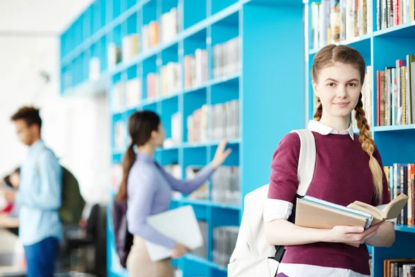 Uno Los Estudiantes Con Varios Libros Mirando Cámara Biblioteca Fondo — Foto de Stock