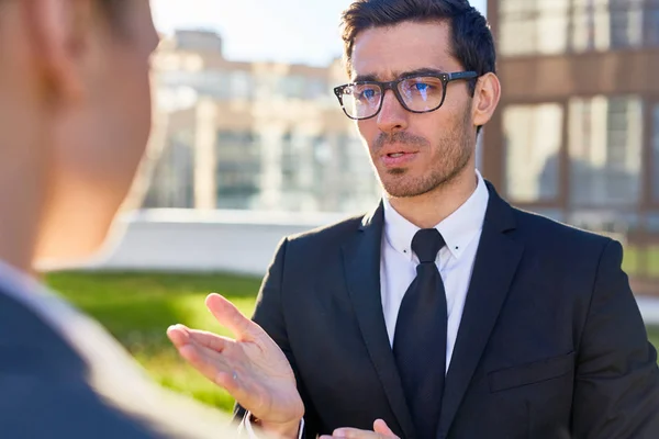 Joven Empresario Contemporáneo Gafas Traje Explicando Puntos Trabajo Colega Discutiendo —  Fotos de Stock