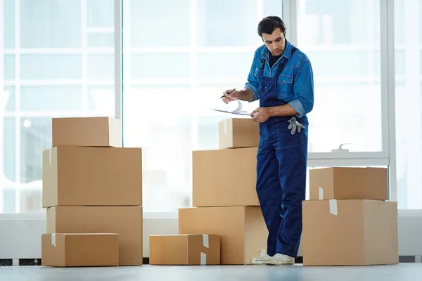 Trabajador Servicio Uniforme Mirando Una Las Cajas Pila Mientras Lee — Foto de Stock