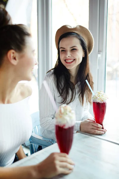 カフェでカクテルを飲み 話の中に彼女の友人を見て歯を見せて笑顔でハッピー ガール — ストック写真