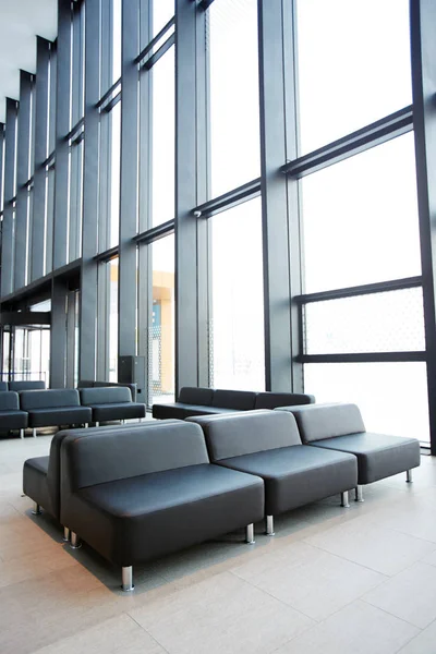 Σειρές Μαύρα Δερμάτινα Καθίσματα Καναπέδες Μαζί Μεγάλα Παράθυρα Στην Αίθουσα — Φωτογραφία Αρχείου