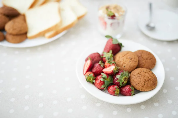 新鲜成熟草莓和燕麦饼干在白色瓷碗在被服务的桌 — 图库照片