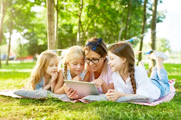 Drei Süße Mädchen Und Ihr Lehrer Mit Tablet Schauen Neugierige — Stockfoto