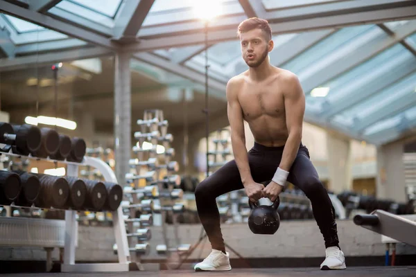 Starker Junger Mann Macht Schwierige Übungen Mit Schwerer Kettlebell Während — Stockfoto