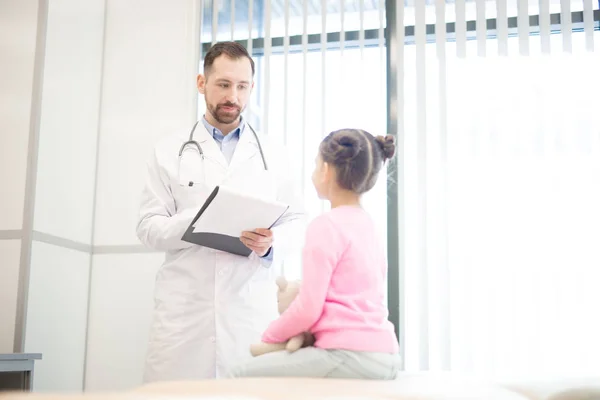 Young Clinician Listening His Little Patient Making Notes Medical Card — Stock Photo, Image