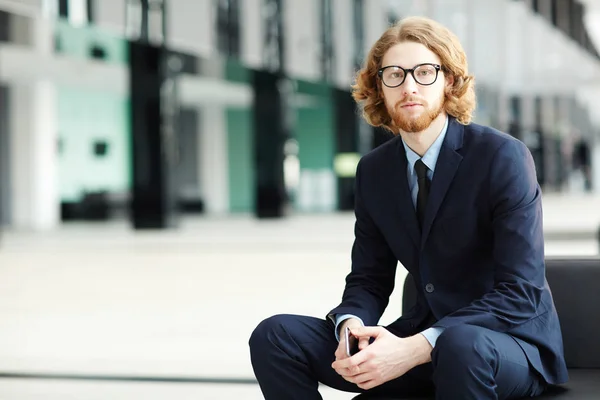 Σοβαρές Νεαρός Επιχειρηματίας Στο Κομψό Κοστούμι Κάθεται Στο Χώρο Αναμονής — Φωτογραφία Αρχείου