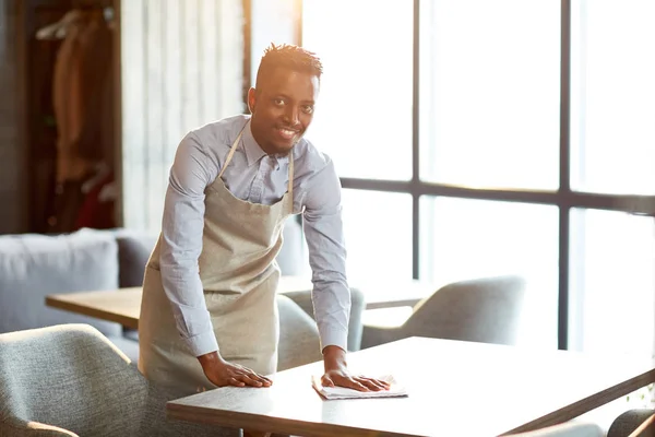 Serveur Heureux Uniforme Vous Regardant Tout Nettoyant Une Des Tables — Photo