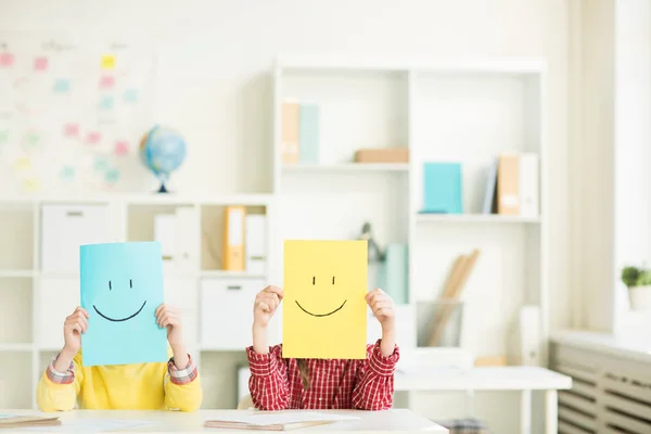 Gelbe Und Blaue Papiere Mit Gezeichnetem Lächeln Das Zwei Jugendliche — Stockfoto