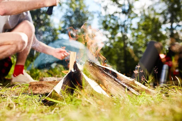 年轻童子军在夏天的旅途中 在草地上为篝火修剪木柴 — 图库照片