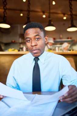 Genç ciddi Ajan istemci kafede randevu öncesi mali belgeleri hazırlama