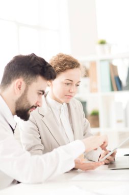 İşadamı ve masada oturan ve dijital tablet birlikte kullanarak iş kadını