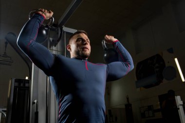 Ağır kettlebells silahlarla tatbikatların pratik giyim kas atlet