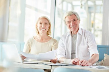 Toplantıda mali belgeleri ile çalışırken kameraya bakarak iki yaşında arkadaşları