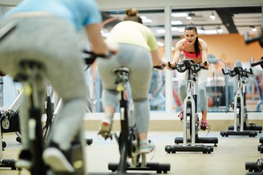 Bisiklete binme eğitmen fitness Bisiklet önünde iki tombul kız eğitim egzersiz genç uyum