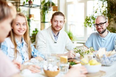 Bir grup genç insan tarafından sunulan tablo öğle yemeği sırasında otururken konuşmayı