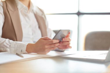 Kadın Yöneticisi tarafından işyerinde ofiste otururken Smartphone ve mesaj atıp tutan