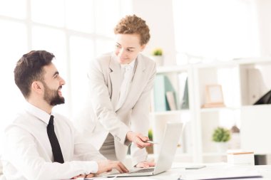 Onun ortağı tanıtımı için bilgisayarda açıklayan iş kadını