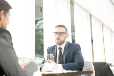 Beyin fırtınası ve yeni iş projesi için fikirler tartışırken kafe ya da Restoran, oturan iki Genç İşadamları