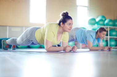 İki boyutlu kadınlar tahta kattaki fitness merkezinde egzersiz sırasında yapıyor