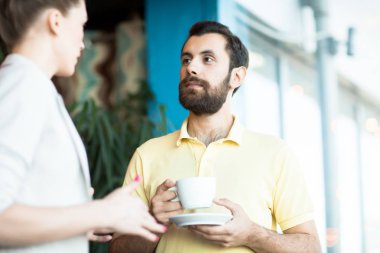 Genç ofis müdürü meslektaşım görüşünü yeni iş planı hakkında dinleme kahve ile