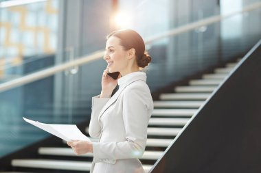 Ortağına telefonda konuşurken ve randevu için anlaşma yapma kağıt ile genç şık iş kadını