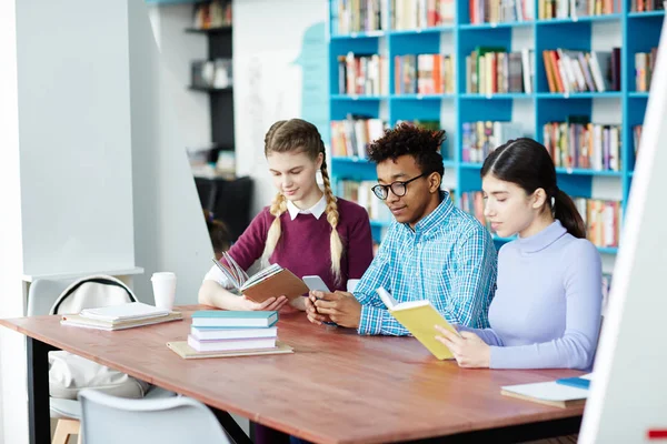 Dos Chicas Leyendo Libros Biblioteca Mientras Chico Entre Ellos Mensajes — Foto de Stock