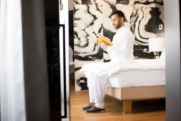 Zeitgenössischer Mann Weißer Kleidung Sitzt Auf Seinem Bett Hotelzimmer Oder — Stockfoto