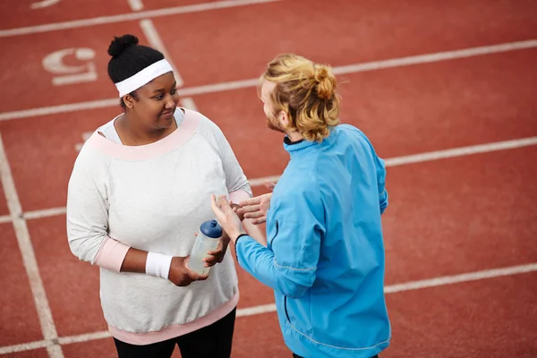 Joven Mujer Regordeta Escuchando Instructora Hablar Sobre Progreso Deporte —  Fotos de Stock