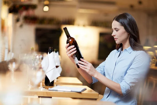 Female Sommelier Holding Bottle Wine Reading Information — Stock Photo, Image