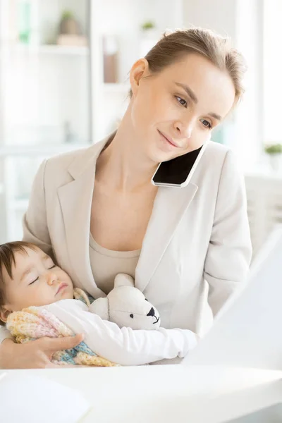 繁忙的年轻女特工与熟睡的女儿阅读财务文件和咨询客户电话 — 图库照片