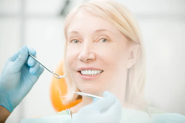快乐的女人看着相机与牙齿微笑 而访问她的牙医检查 — 图库照片