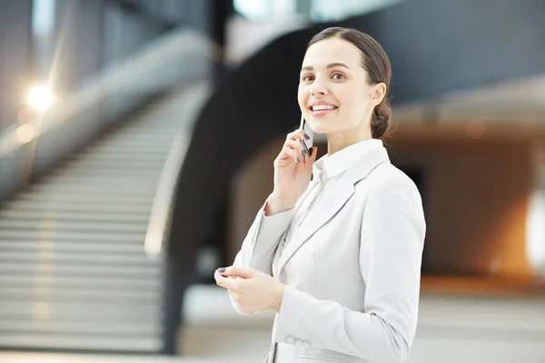 会議旅行後にそれらを収集するために彼女の同僚に電話をかける正装で若手ビジネス リーダー — ストック写真