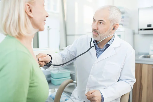Starší Lékař Bělosrstých Při Pohledu Jeho Pacient Během Léčby Stetoskop — Stock fotografie