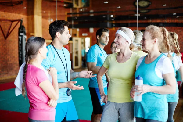 Joven Entrenador Explicando Algunos Momentos Entrenamiento Equipo Tres Mujeres Mayores — Foto de Stock